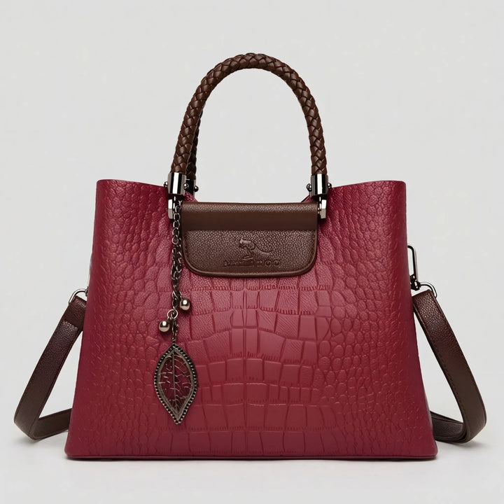 Elegant red embossed women's handbag with a braided shoulder handle, ideal for a stylish everyday look.
