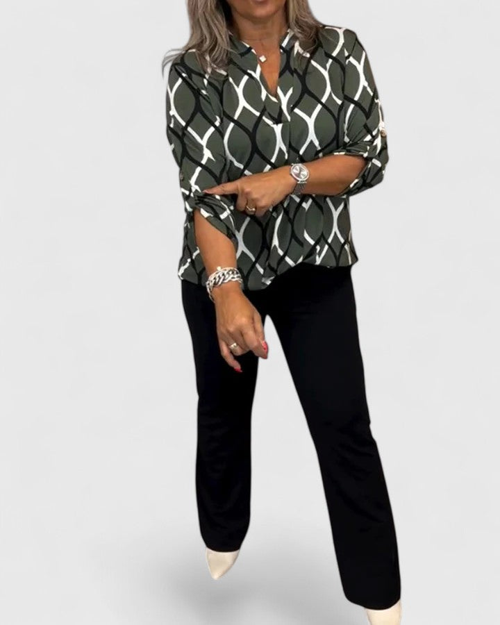 Fashionable graphic print women's blouse with comfortable loose fit and three-quarter sleeves.