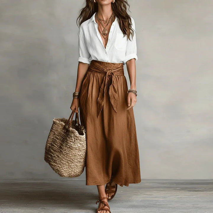 Versatile Women's two-piece Jeanelle skirt set. Effortless long sleeve top paired with a chic tie-waist skirt.