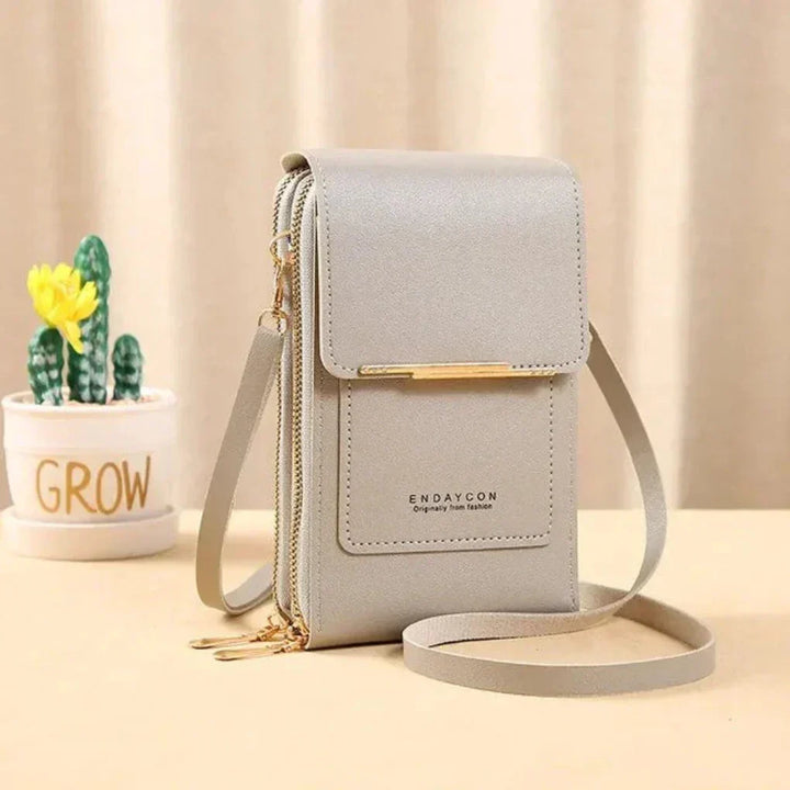 Functional women's accessory: Tan crossbody phone bag with touchscreen capability. Ideal for compact travel.