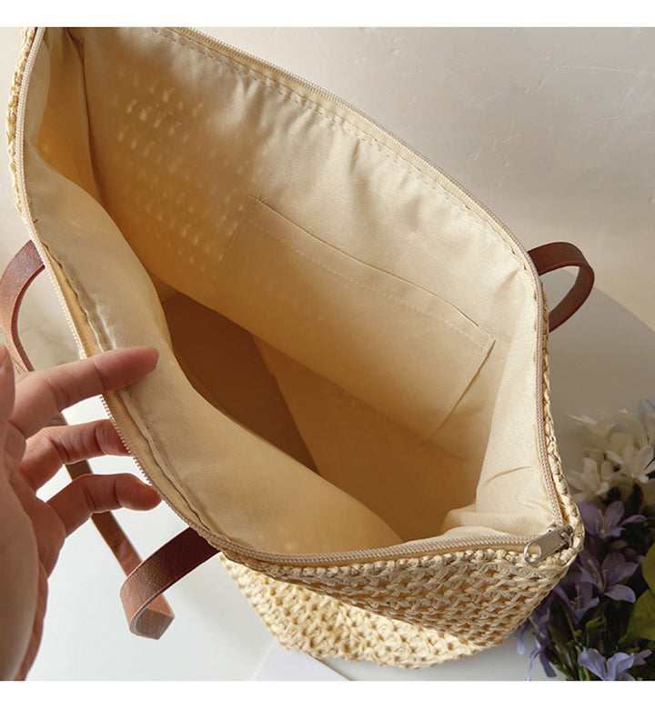 Classic women's rattan woven tote with dark leather straps, a timeless summer bag perfect for everyday elegance.