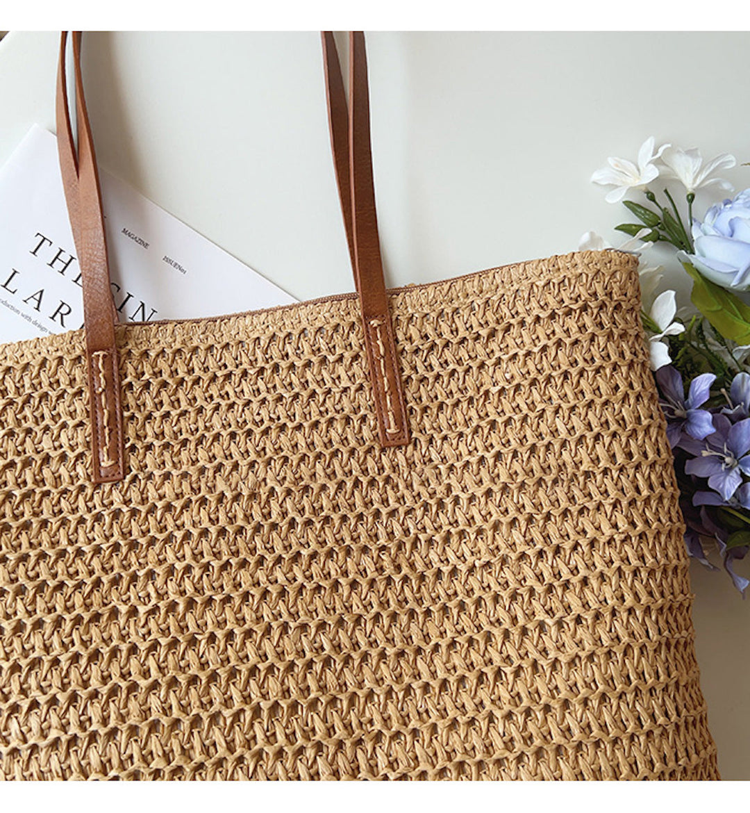 Chic woven rattan beach tote bag for women, featuring sturdy leather handles, ideal for summer vacations.
