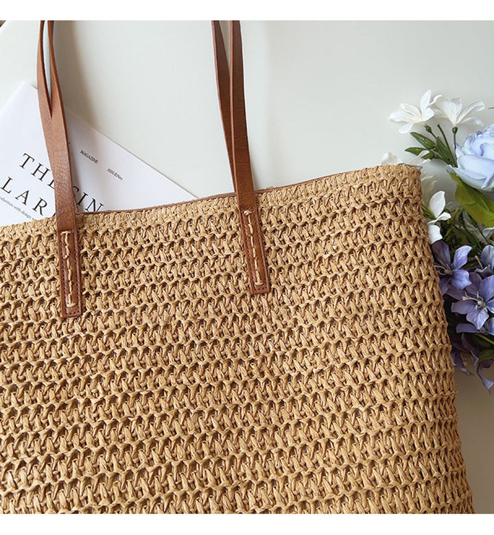 Chic woven rattan beach tote bag for women, featuring sturdy leather handles, ideal for summer vacations.
