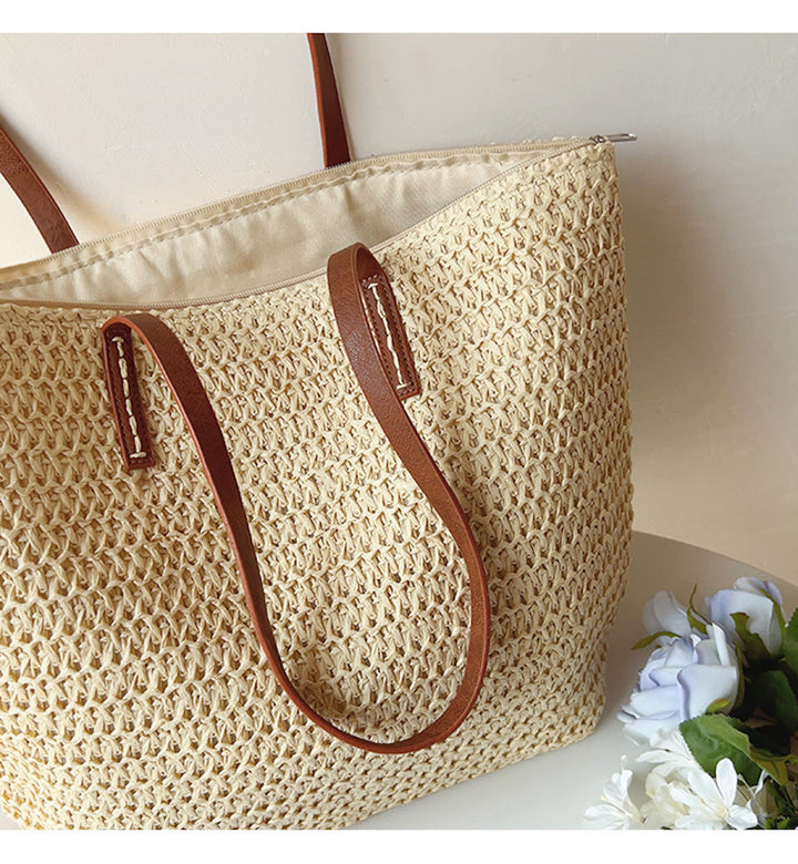 Fashionable women's woven rattan bag, a stylish tote with elegant leather straps for any summer look.