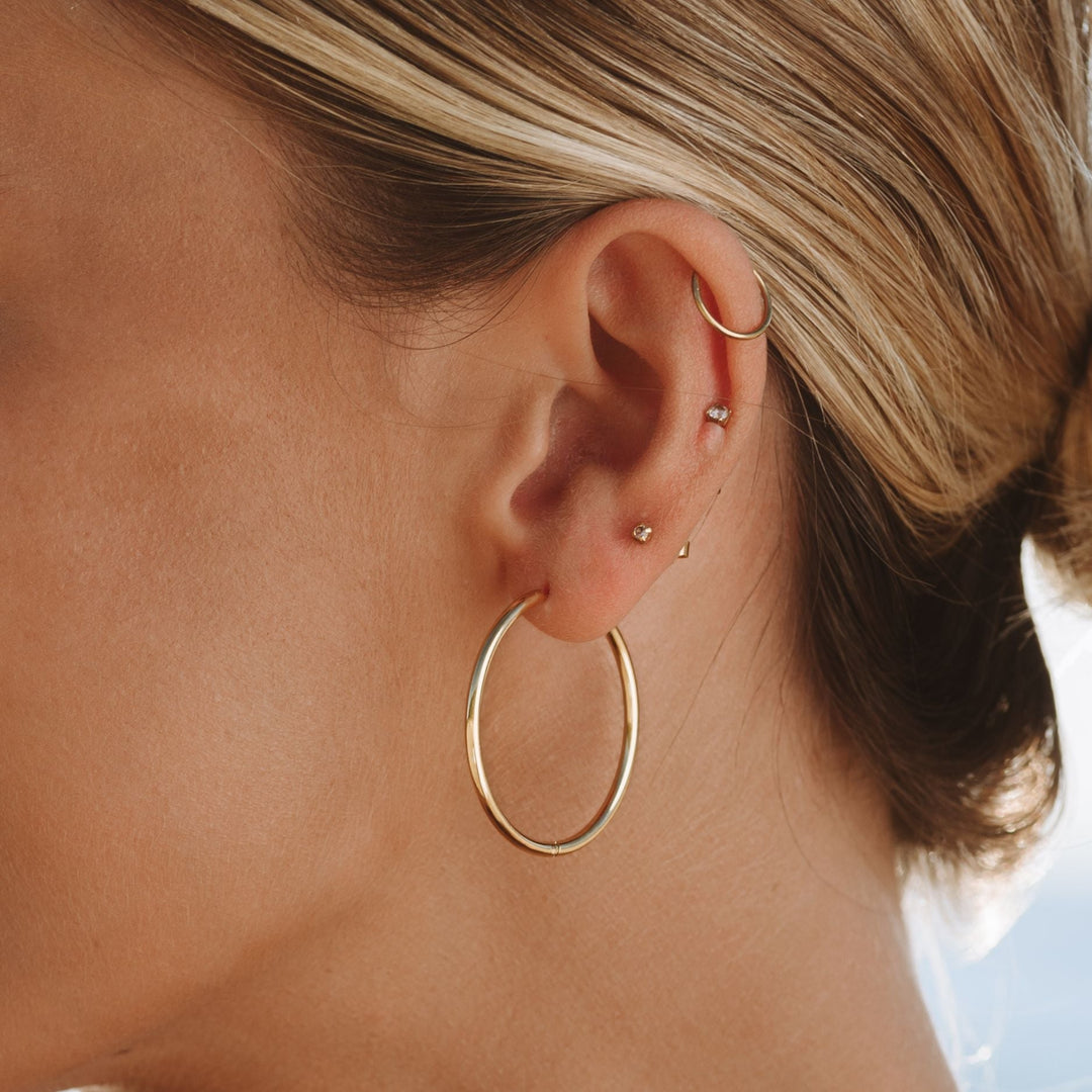 Lightweight thin hoop earrings for women. Comfortable for everyday wear, available in gold and silver.