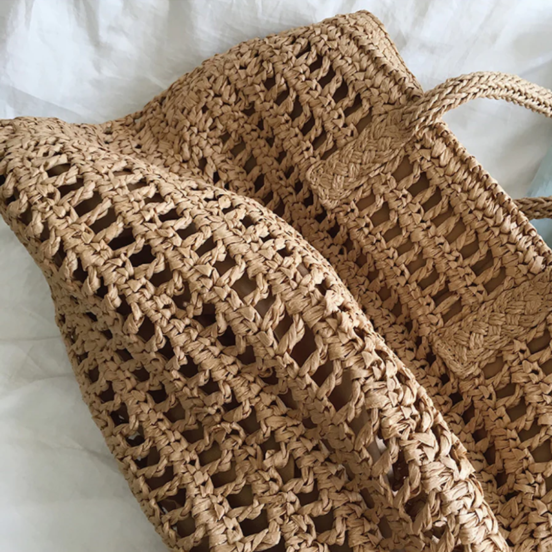 Fashionable women's woven beach tote, a spacious and stylish summer accessory with comfortable shoulder straps.
