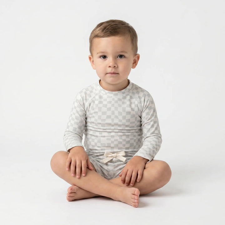 Baby long-sleeve rash guard and swim shorts set, ideal for sun-safe infant water play.