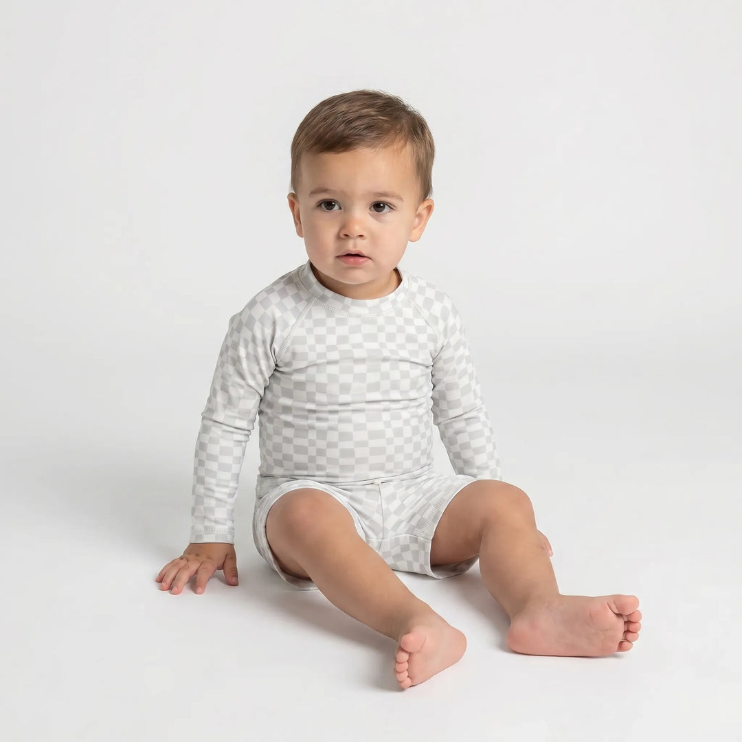 Vibrant toddler swimwear set with long sleeves & secure fit shorts for sun protection during summer vacation.