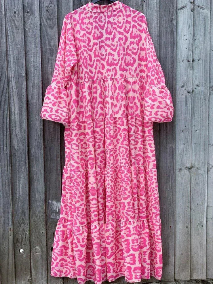 Elegant pink leopard print maxi dress with flowing bell sleeves. A versatile V-neck summer dress for chic occasion wear.