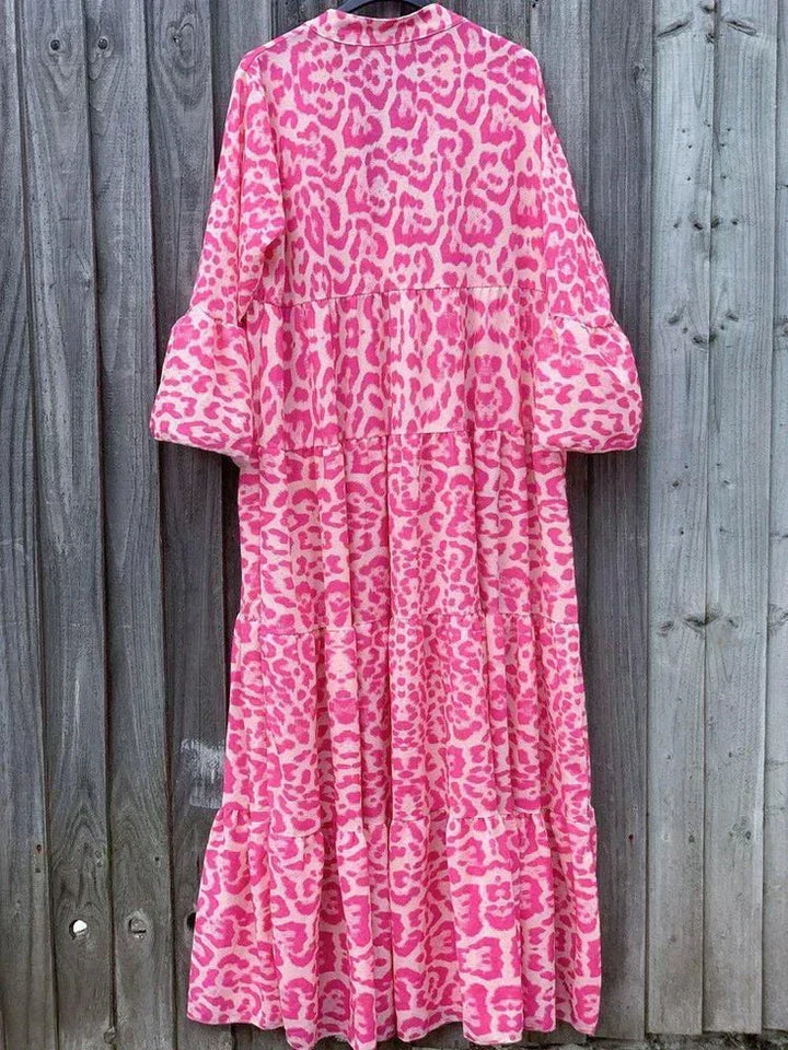 Elegant pink leopard print maxi dress with flowing bell sleeves. A versatile V-neck summer dress for chic occasion wear.