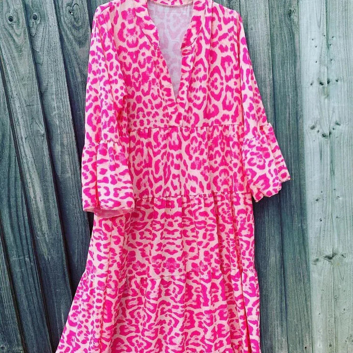 Fashionable women's maxi dress in pink leopard print. Features V-neck, bell sleeves. A chic, comfortable summer outfit.
