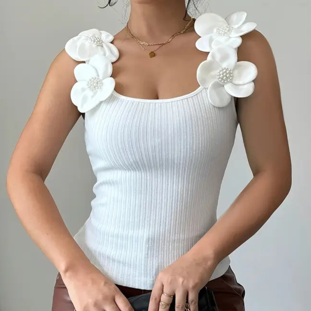 Trendy white sleeveless top for women, delicate floral & pearl accents. Ideal for summer casual chic.