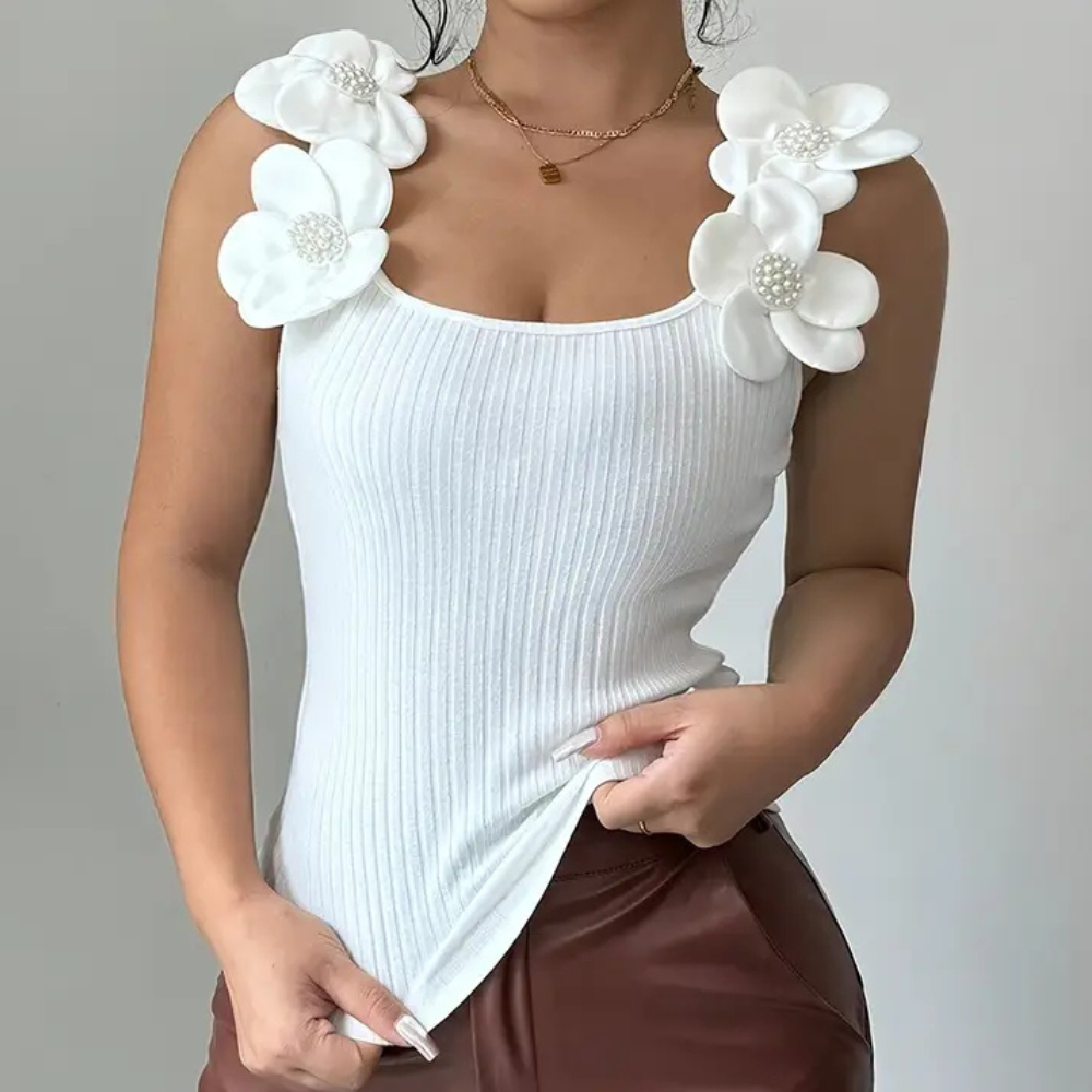 Stylish white sleeveless top with intricate floral accents for women. A trendy choice for spring & summer.