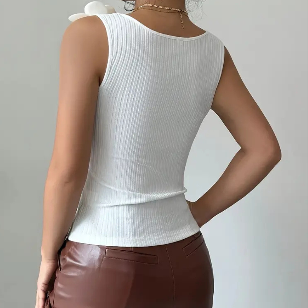 Fashionable white sleeveless top for women, decorated with elegant floral motifs. Great for casual or party.