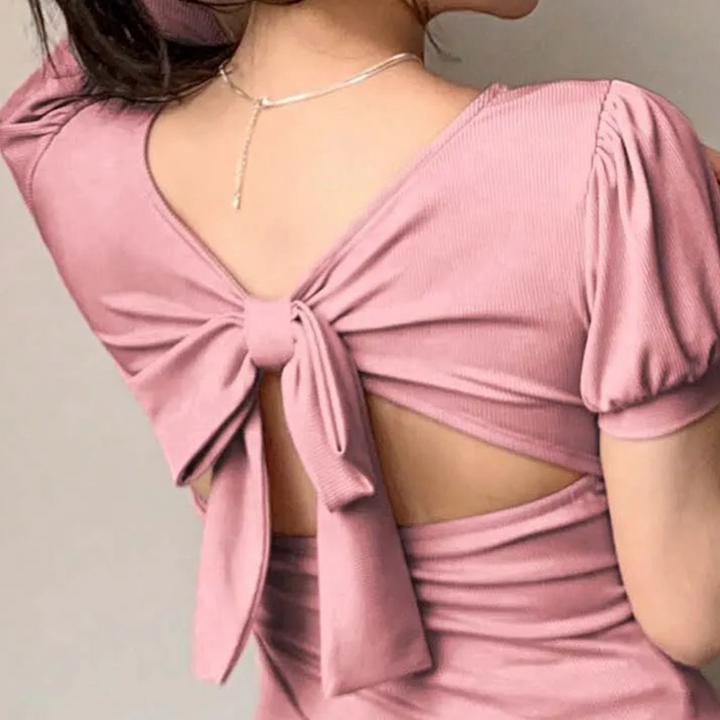 Elegant ladies pink top with a flattering square neckline and fashionable puff sleeves, ideal for trendy apparel.