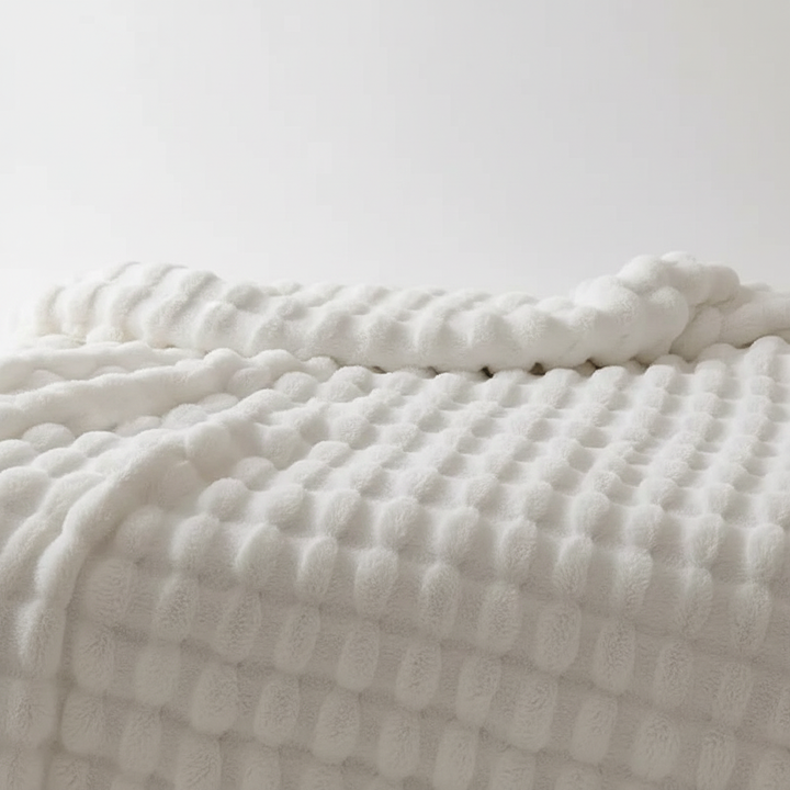 Closeup of a luxurious, all-season plush throw blanket, highlighting its soft texture for comfort.