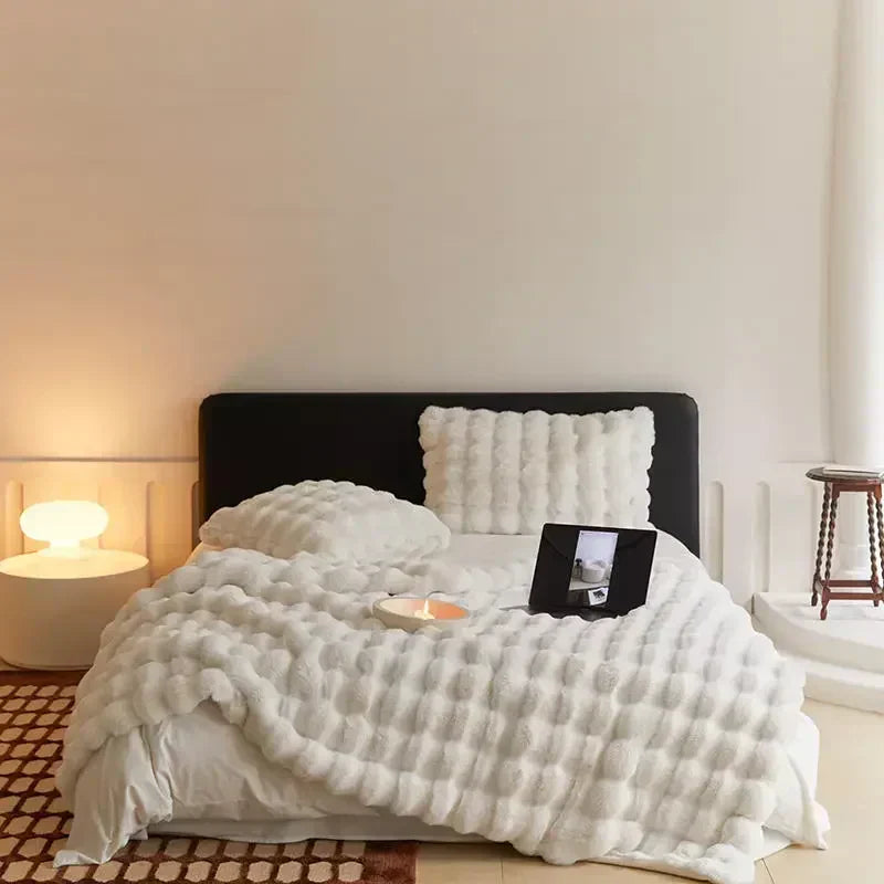 Folded plush throw blanket, ready for use as bedding or an extra layer of warmth and comfort.