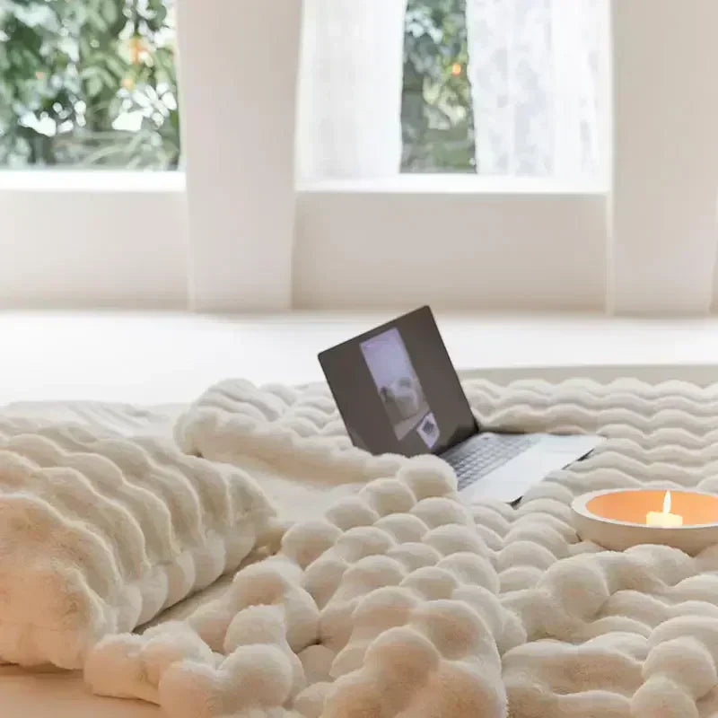 Stylish plush throw blanket on a bed, providing warmth and a touch of elegance to home decor.