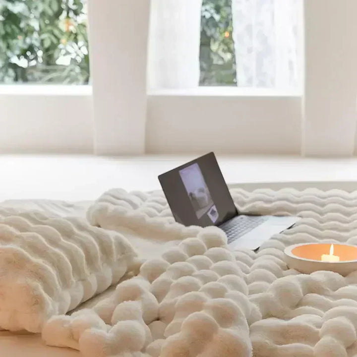 Stylish plush throw blanket on a bed, providing warmth and a touch of elegance to home decor.