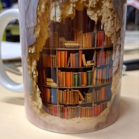 Enjoy your brew with this unique 3D bookshelf library coffee mug, a must-have ceramic cup for any reader.