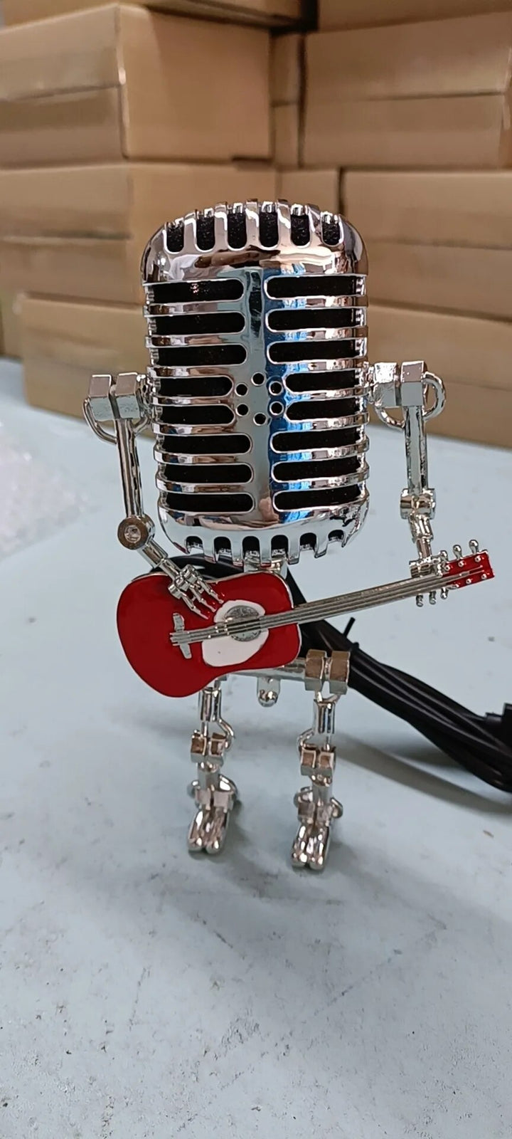 Stylish industrial robot desk lamp holding a guitar, an eye-catching accent light for unique decor.
