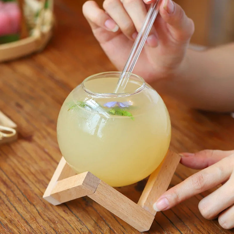 Stylish moon ball beverage glass with a sturdy wooden stand, ideal for cocktails, water, or as a distinctive barware gift.