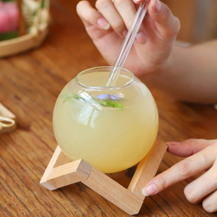 Stylish moon ball beverage glass with a sturdy wooden stand, ideal for cocktails, water, or as a distinctive barware gift.
