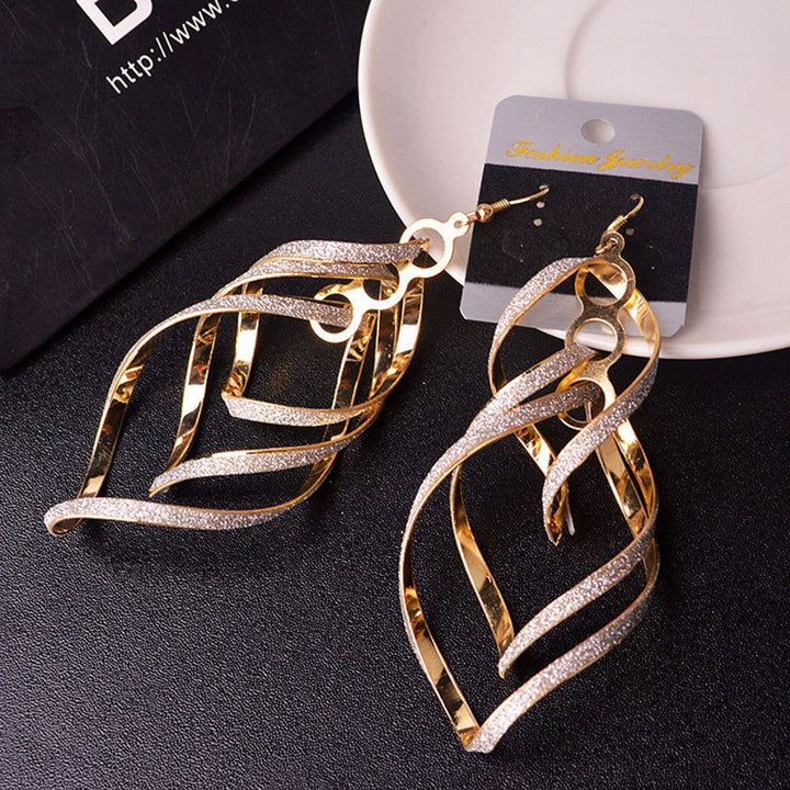Stylish women's golden spiral statement earrings. Unique dangle jewelry for a distinctive look.