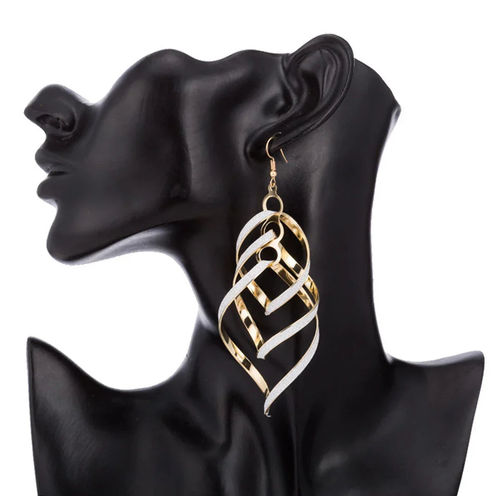 Golden spiral statement earrings, unique women's fashion jewelry. Gold-plated dangle design.