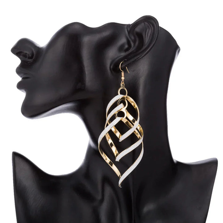 Golden spiral statement earrings, unique women's fashion jewelry. Gold-plated dangle design.