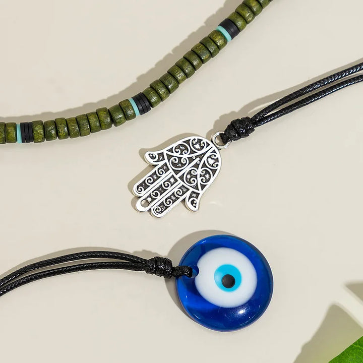 Detailed view of a unisex layered necklace set showcasing symbolic evil eye, Hamsa hand, and pearl design.
