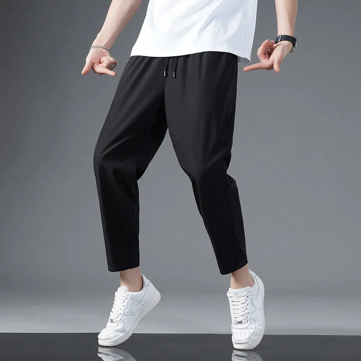 Close-up: lightweight, moisture-wicking fabric of unisex performance pants. Soft, stretchy activewear for comfort.