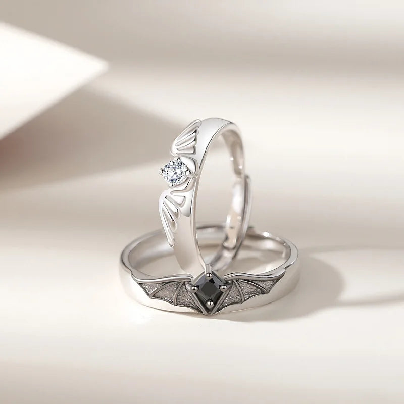 Two hands wearing the adjustable Angel and Demon couple ring set. Features crystal accents and a nontarnish finish.