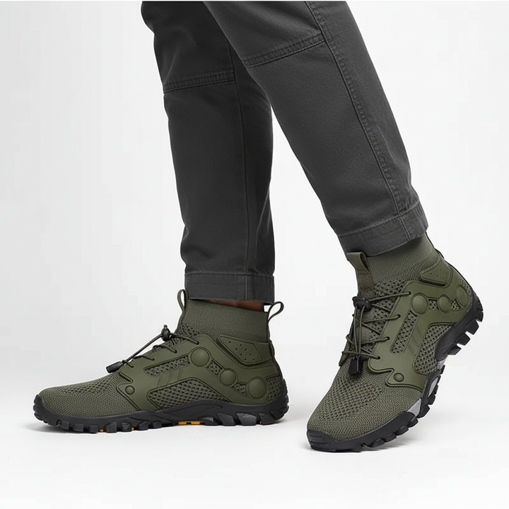 Pair of black barefoot style high-shaft 'Cameron' trekking shoes on a rocky trail, outdoor footwear