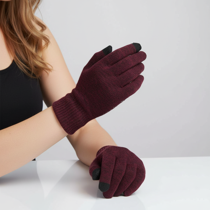 Pair of black thermal touchscreen gloves on a snowy background