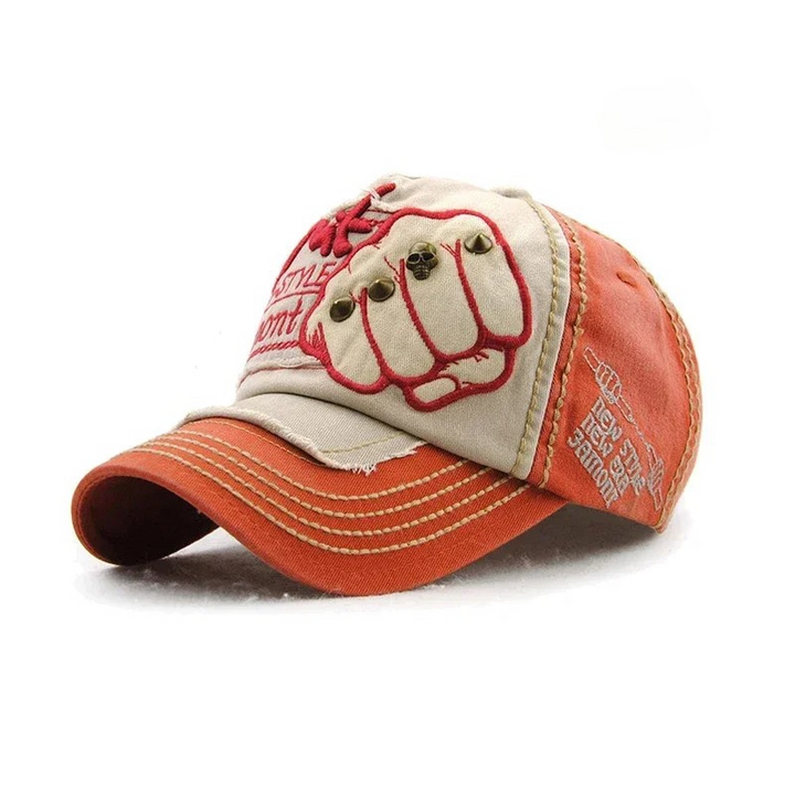 Stylish unisex denim hat, a baseball cap with a prominent embroidered fist and cool metal stud accents.