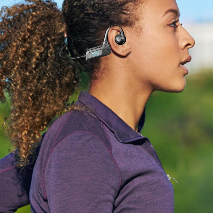 Person wearing Audyra wireless bone conduction sports headphones during an outdoor run, grey color