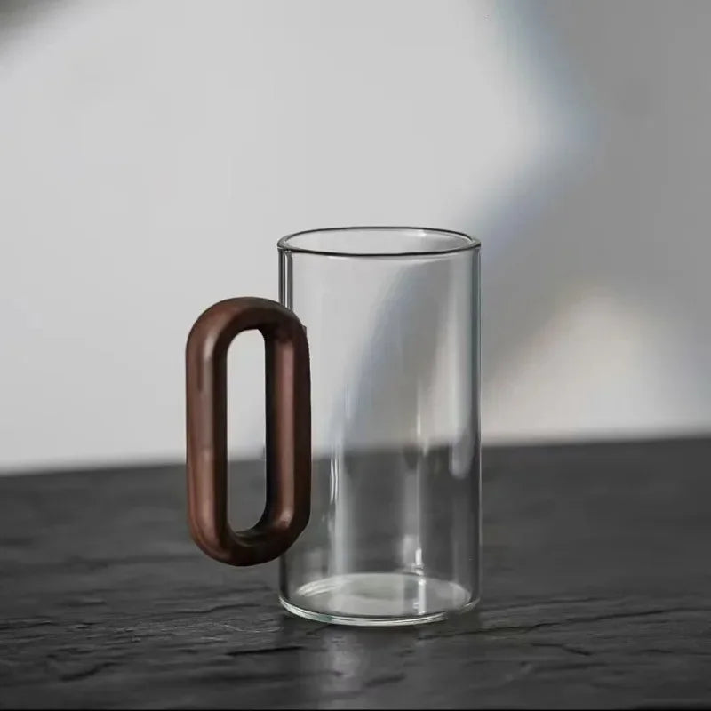 Clear borosilicate glass coffee mug, showing off a rich walnut handle. Elegant and durable kitchenware.