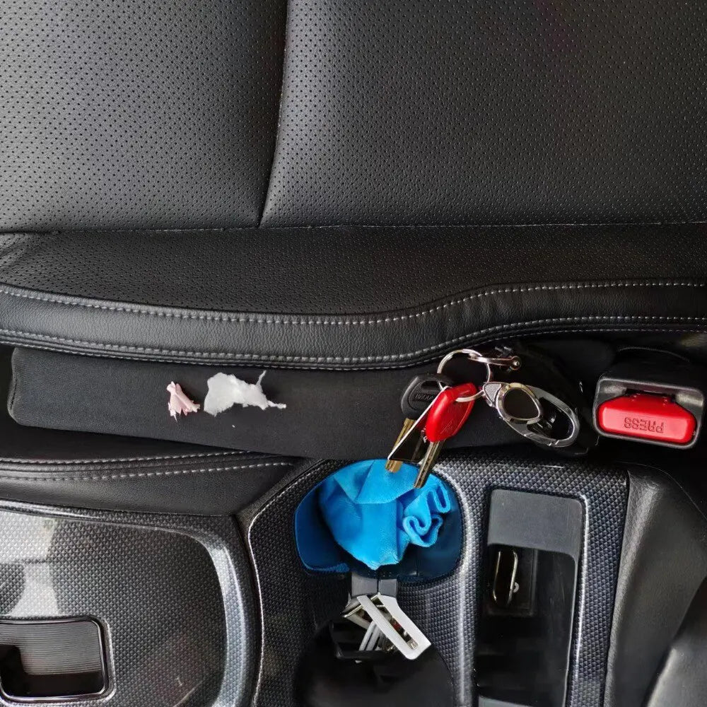 Two black car seat gap fillers. Spill-proof strips prevent items from falling into car seat gaps.