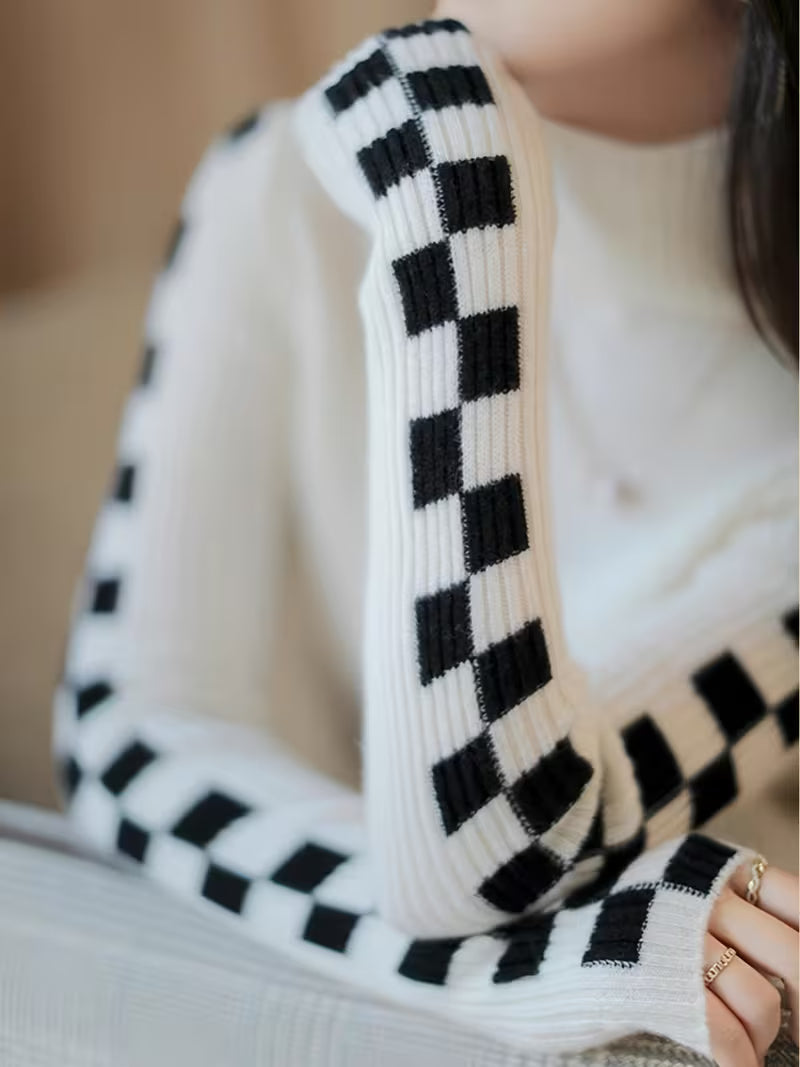 Stylish unisex turtleneck sweater with a distinct checkerboard sleeve design. A modern fit.