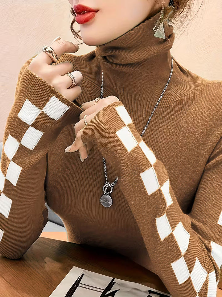 Cozy unisex high-neck sweater with trendy checkerboard sleeves. Essential winter fashion.