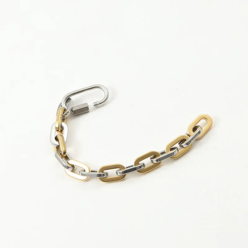 Modern chunky two-tone gold-plated bracelet featuring a stylish carabiner clasp. Unisex statement jewelry.
