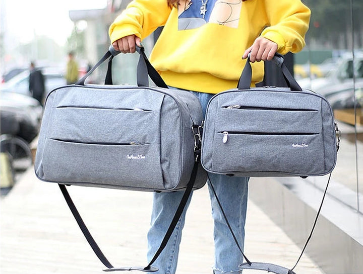 Unisex convertible travel carry-on bag, duffel style, shown with shoulder strap, black color