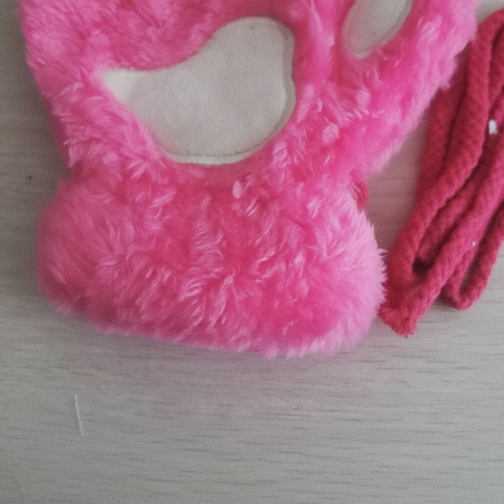 Close-up of plush fingerless paw print gloves in black, showcasing cozy winter accessory