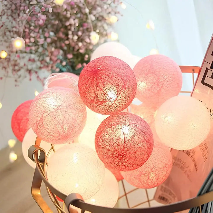 Decorative cotton ball string lights laid out, showing the length and number of lights.