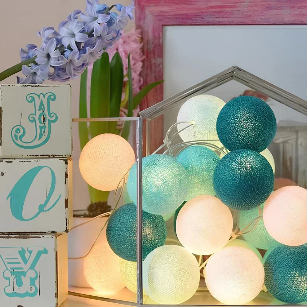 Decorative cotton ball lights arranged in a glass vase, creating a unique table centerpiece.