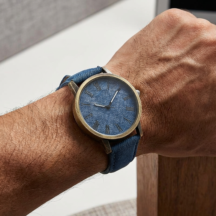 Close-up of a stylish unisex watch featuring a durable denim strap & bronze-tone casing, ideal for streetwear.