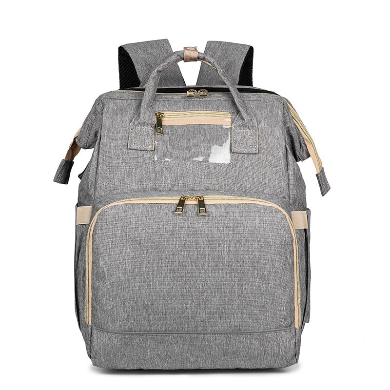 Open waterproof diaper backpack interior with multiple compartments & insulated pockets for baby bottles.