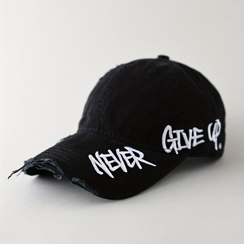 Blue washed denim baseball cap with distressed brim and "Never Give Up" graffiti embroidery. Unisex adjustable.