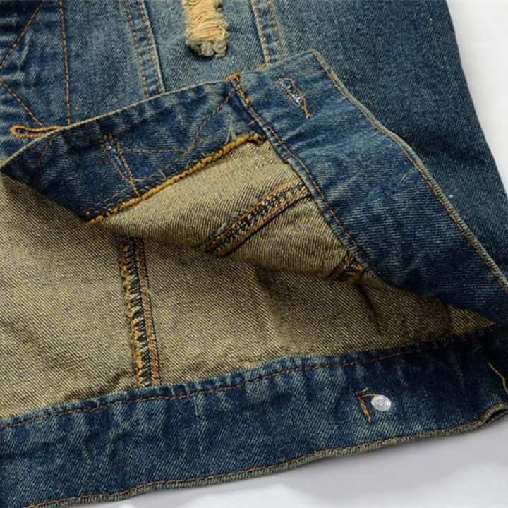 Back view of a distressed heavyweight denim vest, a unisex piece for an undeniable punk aesthetic.